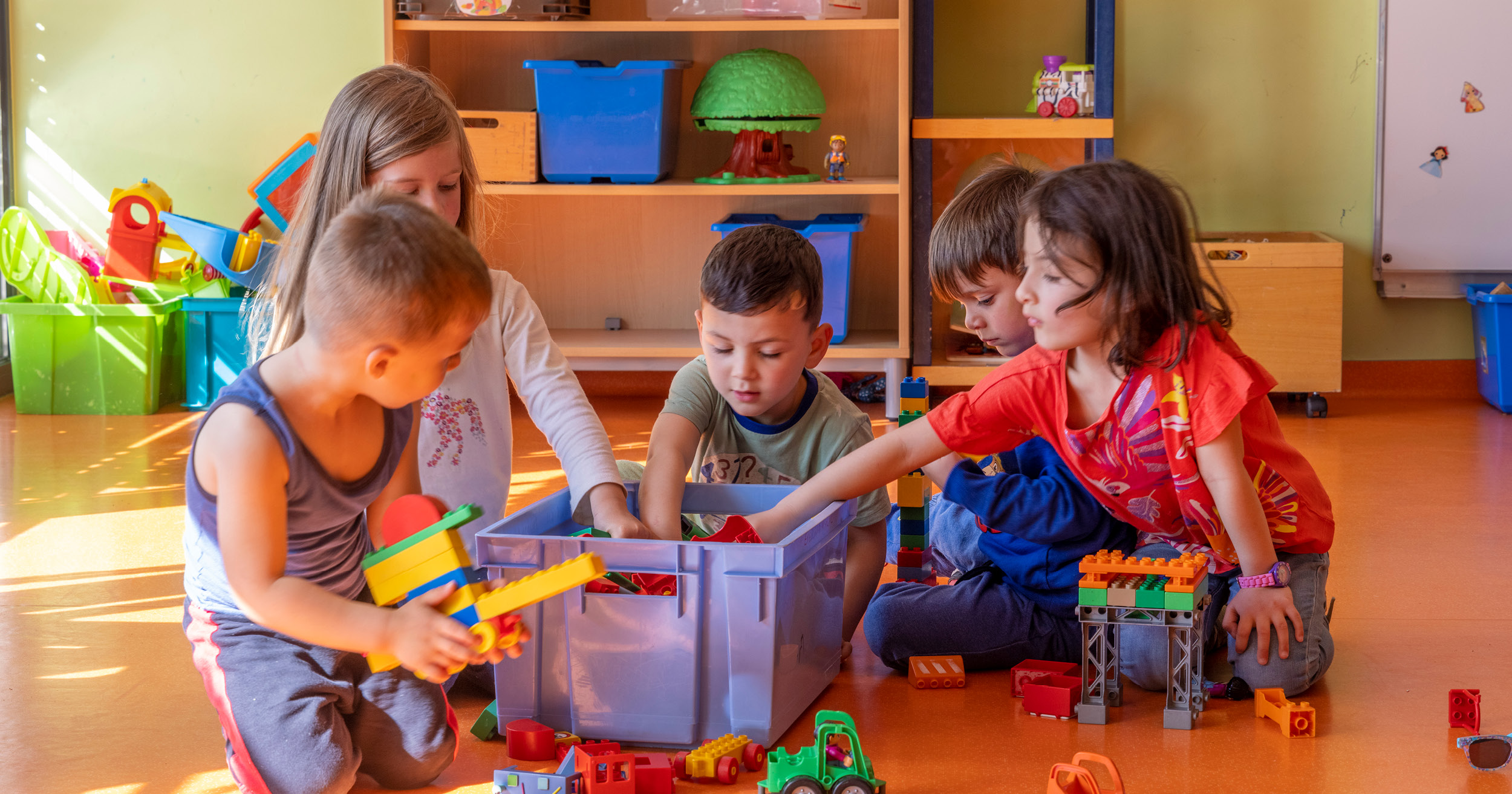 Enfants cherchant des jouets dans un bac